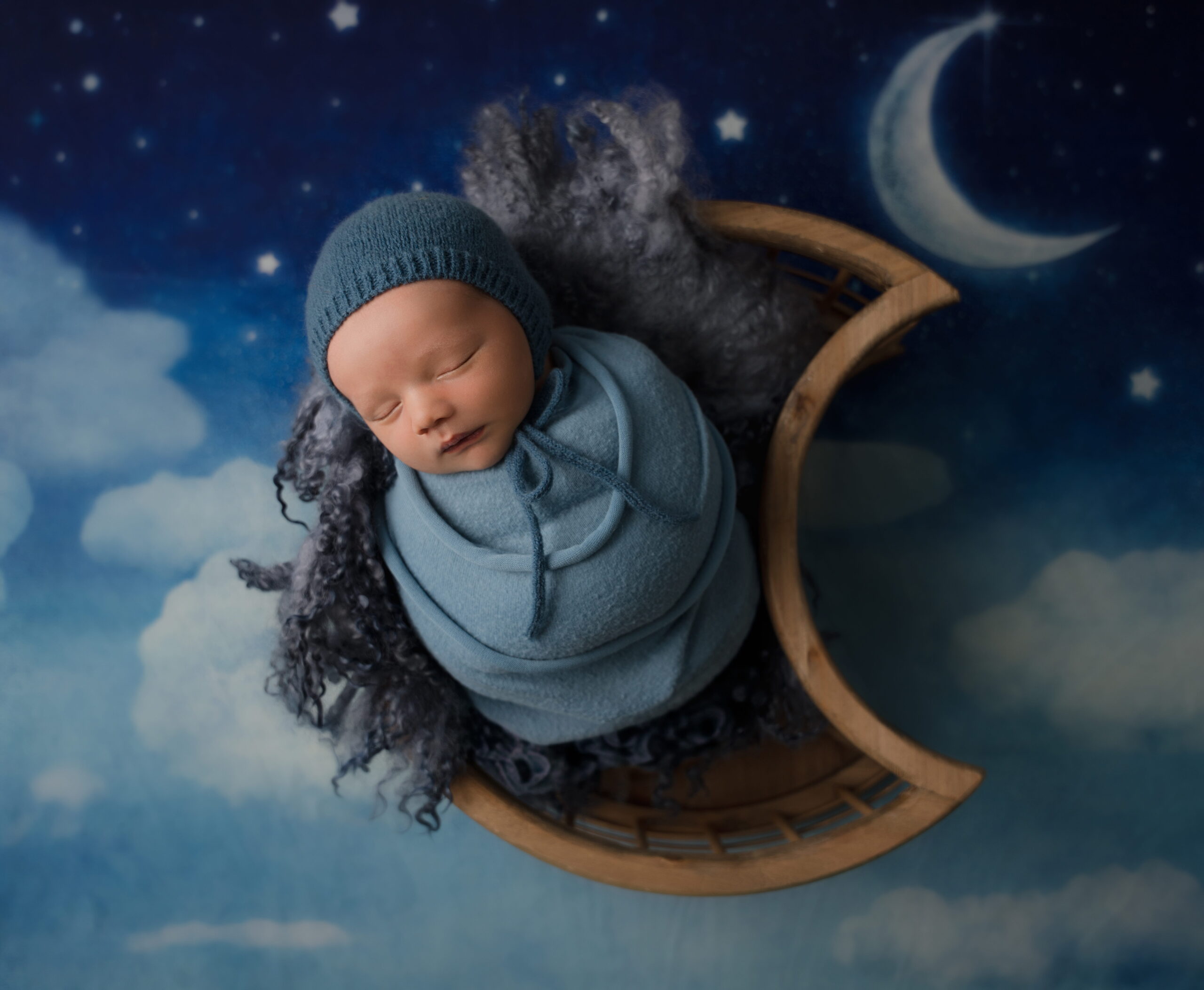 newborn baby boy posed in moon basket wrapped in blue during Apex in home newborn photography session